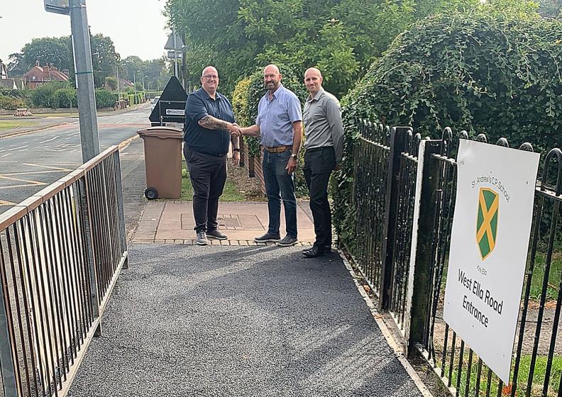 L_R James Stevenson, Senior Project Manager at GRAHAM shakes hands with Cllr Gary McMaster, on the new path at St Andrews Primary School, Kirk Ella with Dan Cawthra, Head of Stakeholder & Community Engagement at GRAHAM looking on.