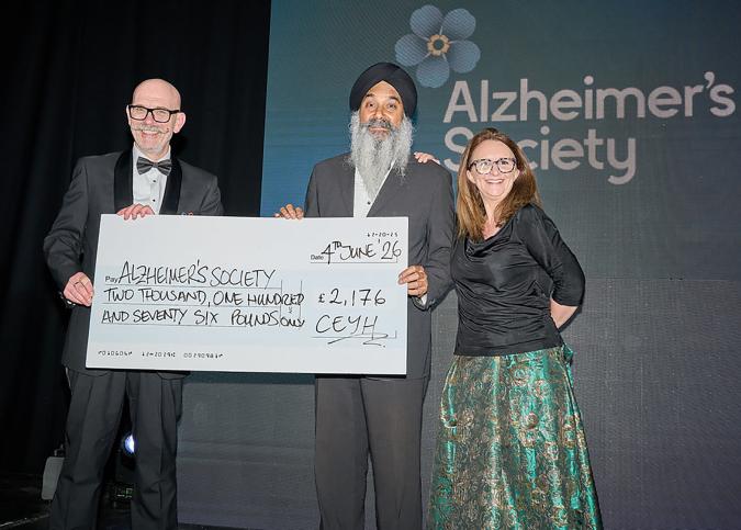 Sam Singh from the Alzheimer's Society receves a cheque for £2176 from Tom Oulton, Chair CEYH and Comedian, Lucy Porter