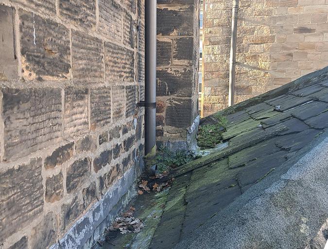 Fall pipes over roofing has allowed water ingress